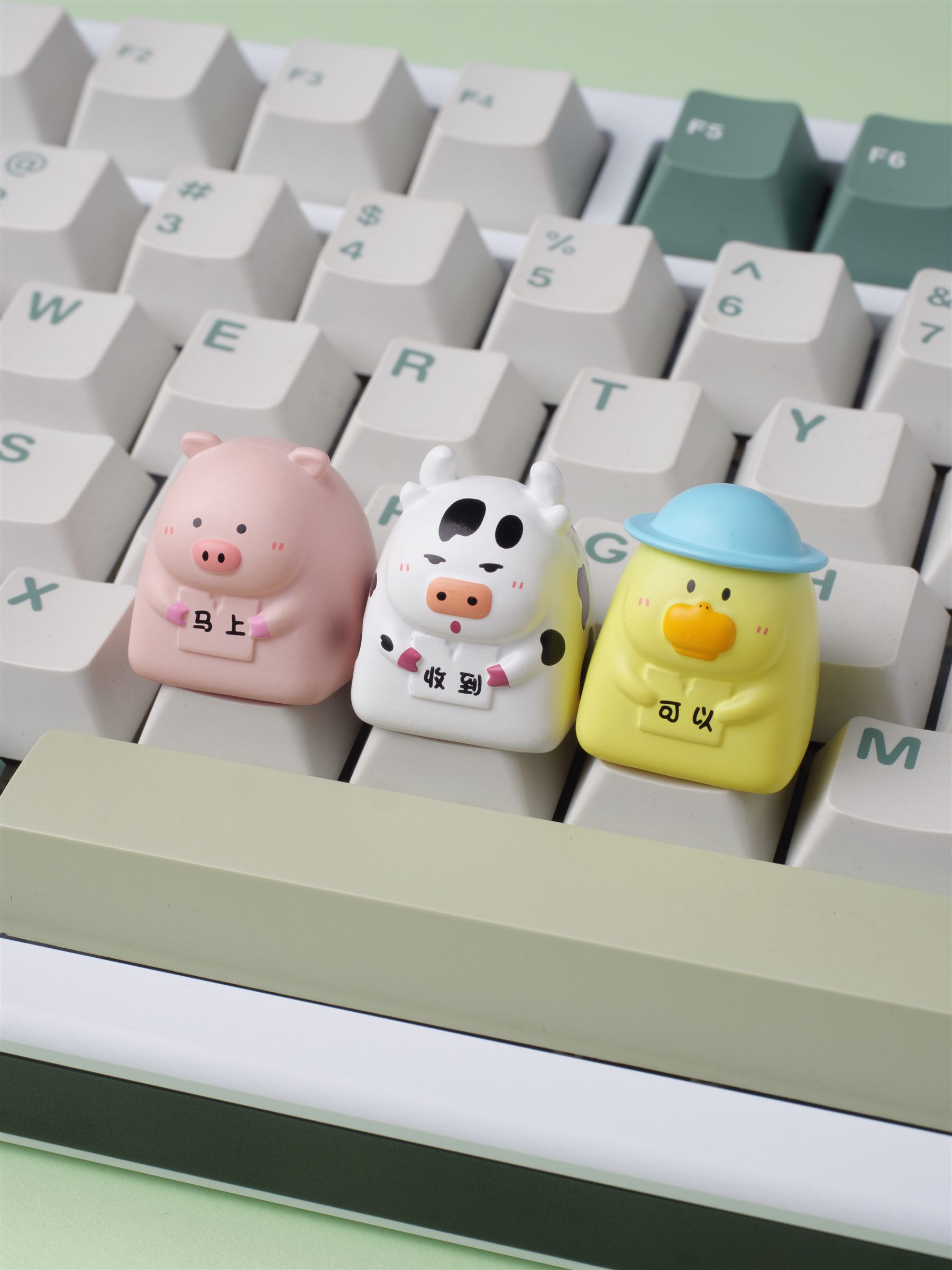 Three custom character artisan keycaps displayed on a mechanical keyboard