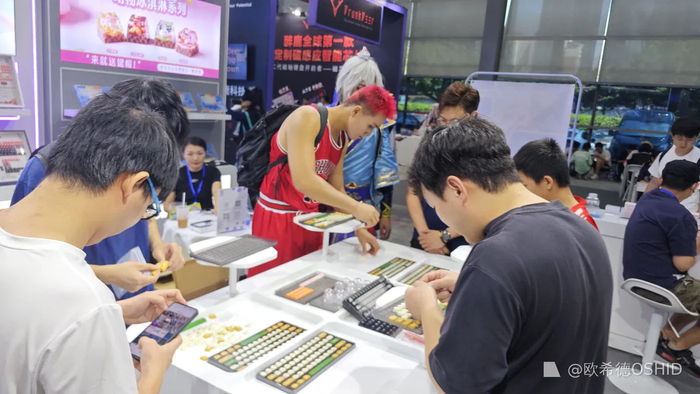 Keyboard buyers testing OSHID keycap samples at an exhibition booth